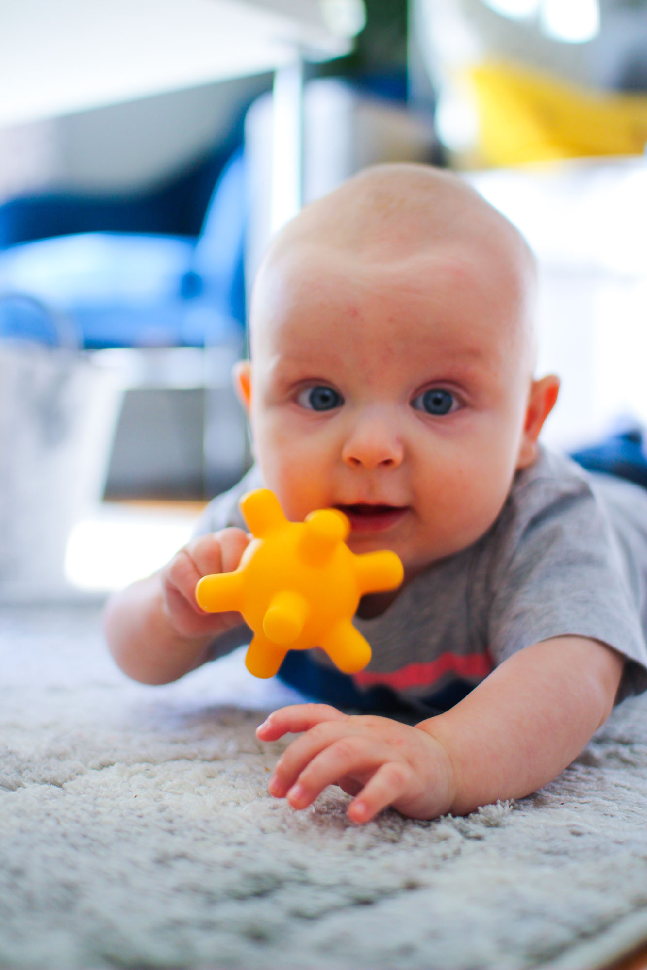 baby lying on tummy with toy