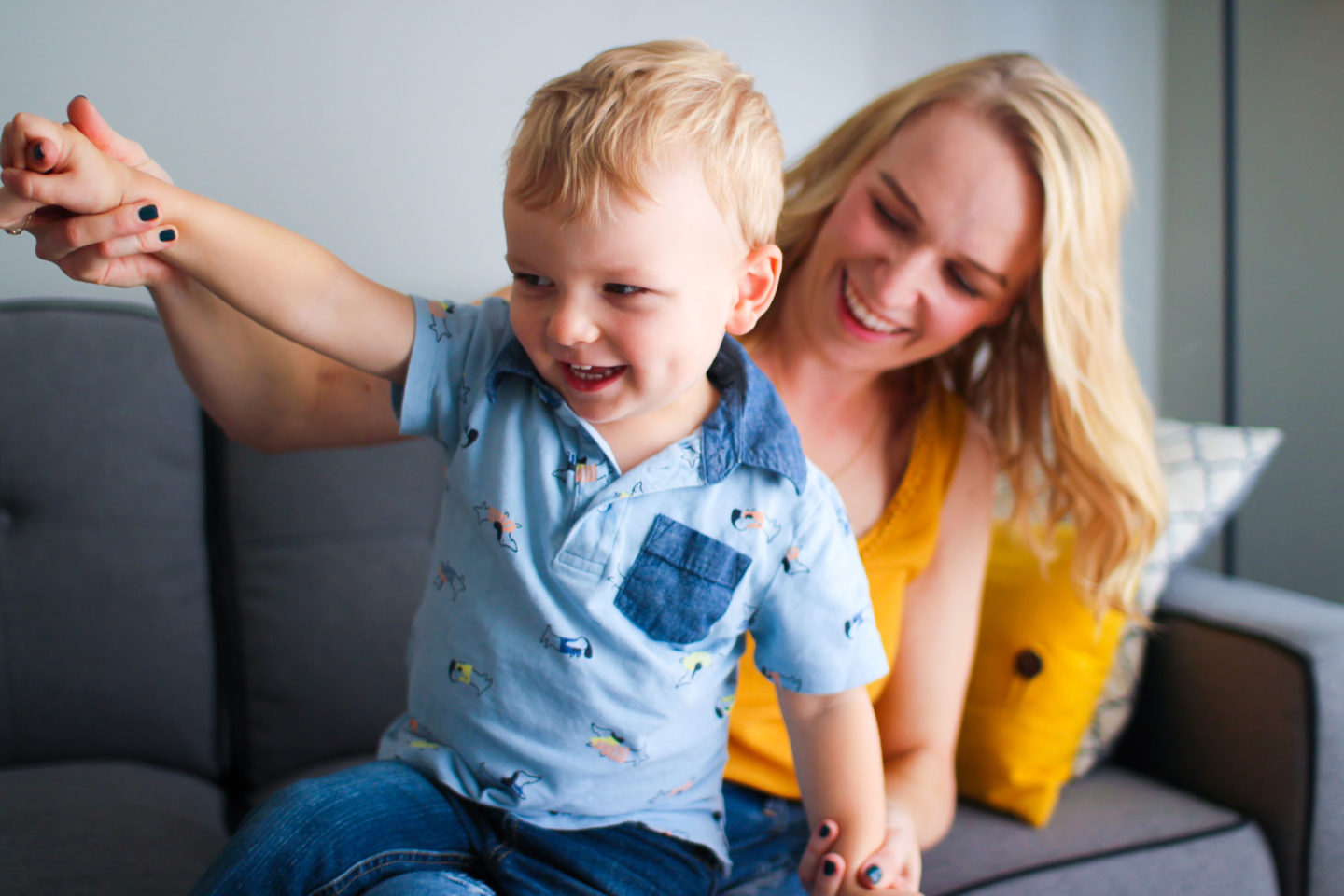 mom playing on couch with toddler son