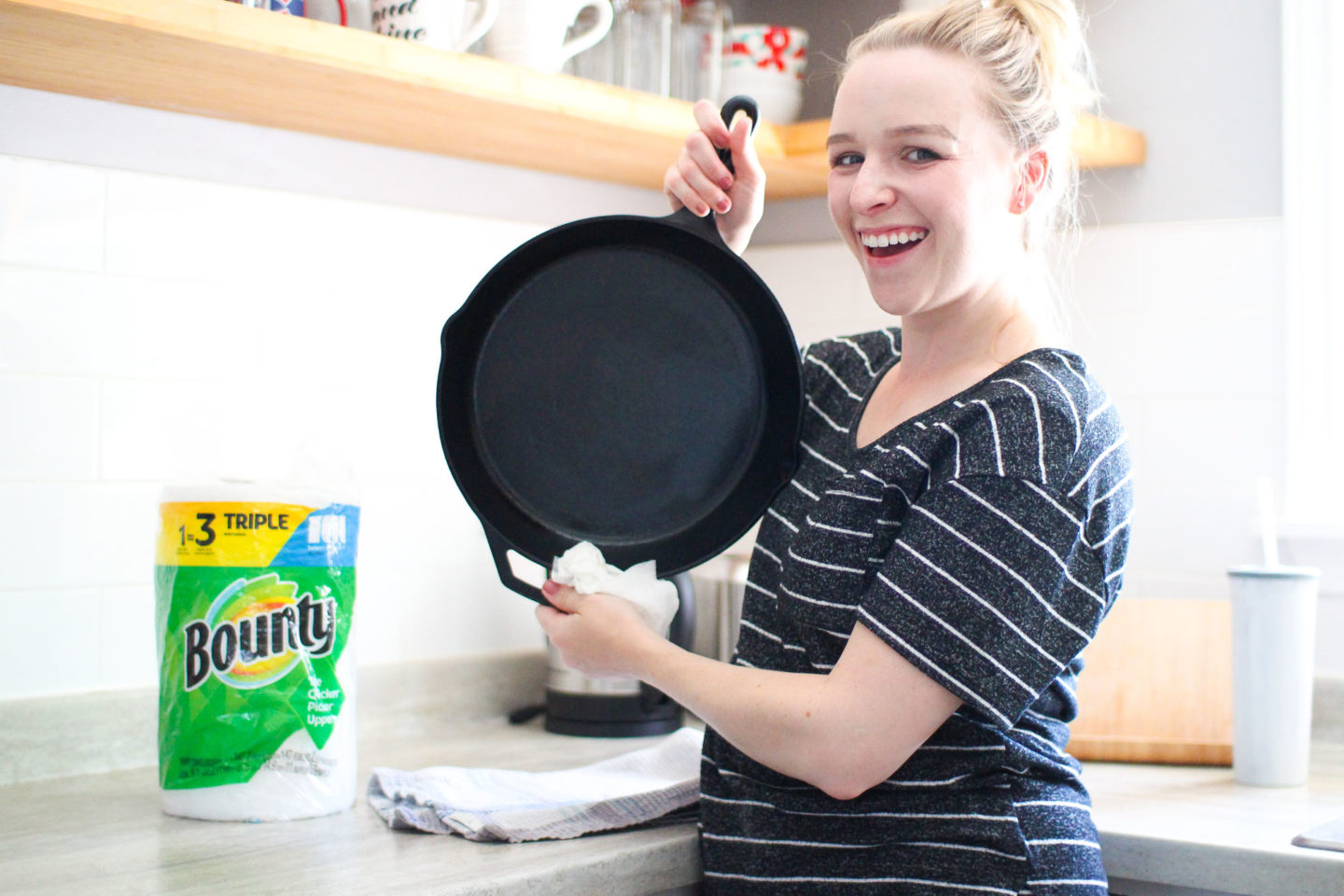 woman holding frying pan with bounty paper towels in background