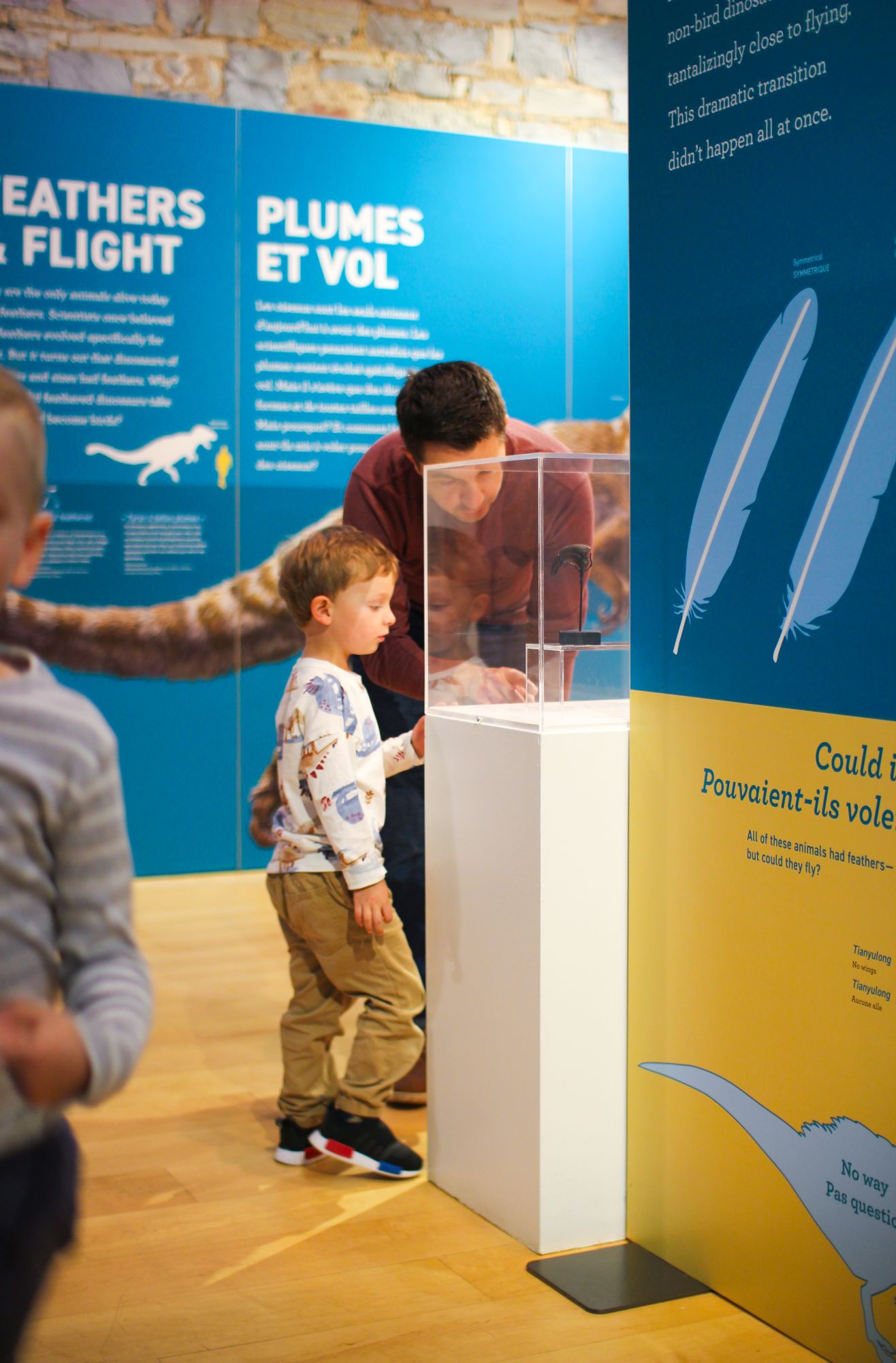 little boy and his father looking at a dinosaur artifact at the pumphouse museum in kingston ontario