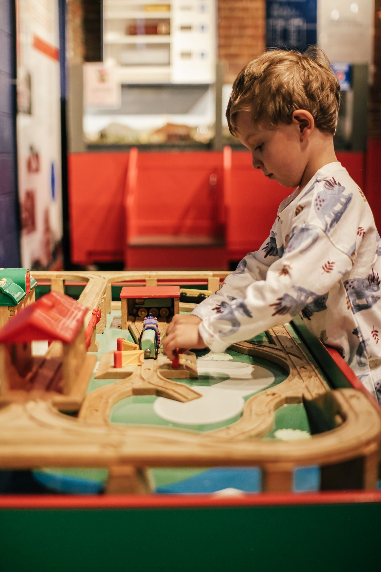 little boy playing with trains at the swyrich train room 